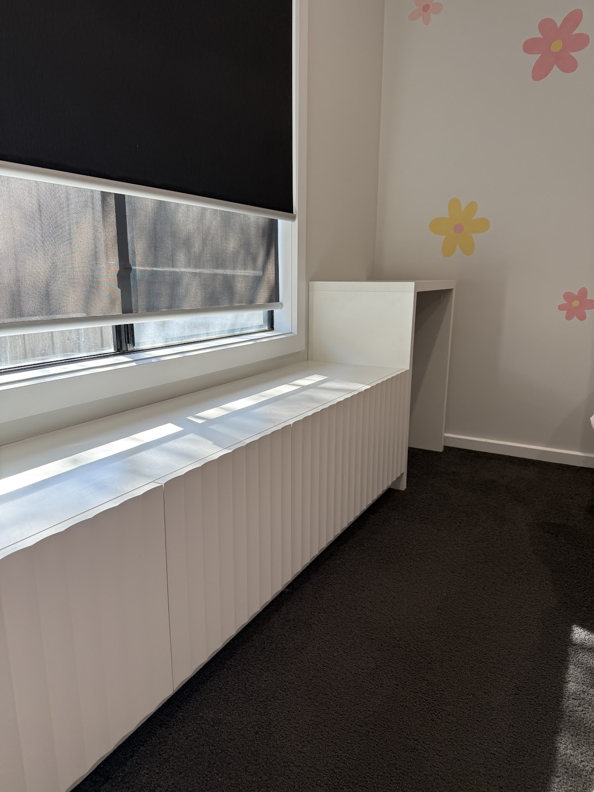 White panelled window seat and desk in a child's bedroom